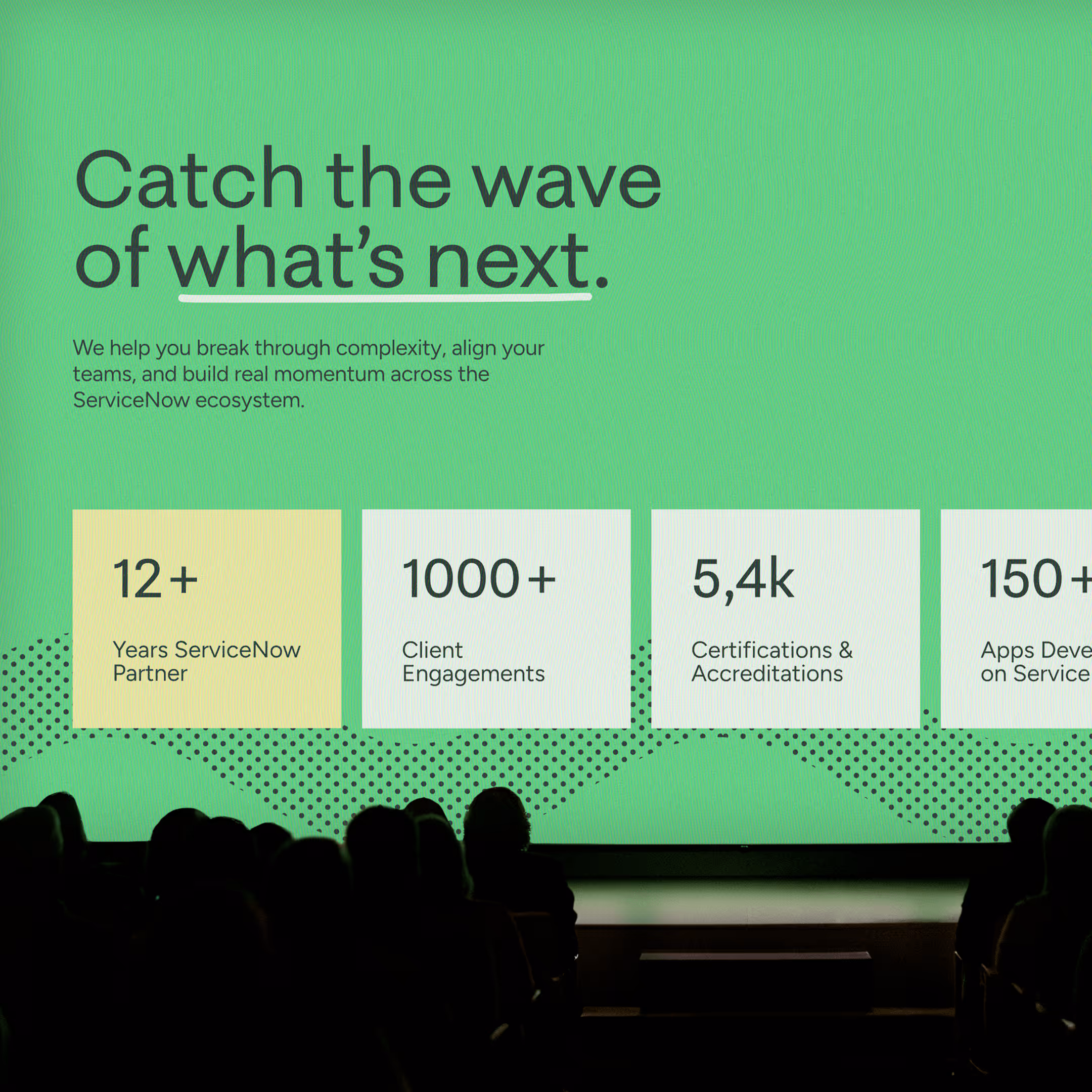Presentation slide with green background and bold text reading 'Catch the wave of what’s next.' followed by statistics about ServiceNow partnership, client engagements, certifications, and app development, with audience silhouettes in foreground.