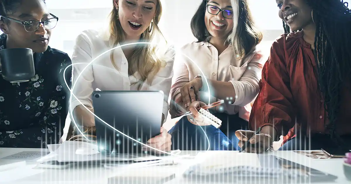 Equipe de profissionais analisando dados em tablet durante reunião de assessoria de imprensa para empresas de tecnologia.