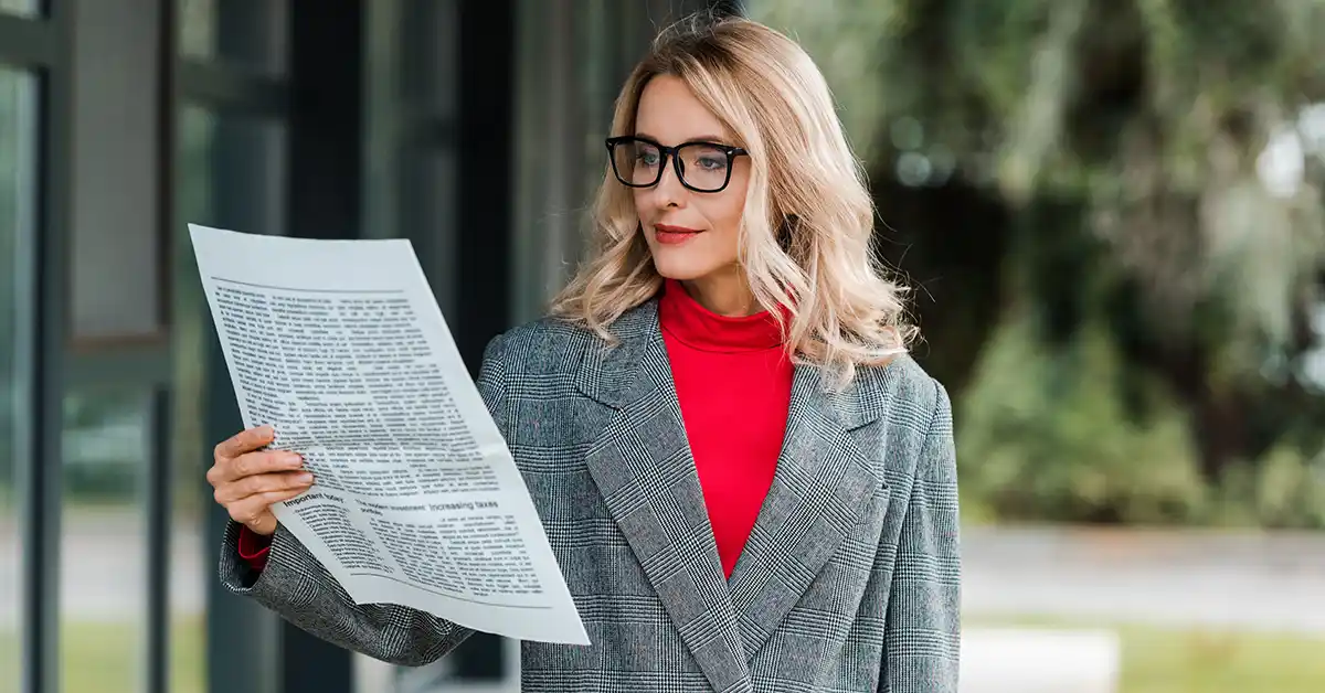 Mulher lendo jornal, representando o conceito de assessoria de imprensa para startups de tecnologia e a busca por visibilidade na mídia.