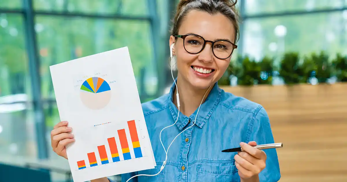 Profissional sorrindo e mostrando gráfico de crescimento, simbolizando a análise de resultados de assessoria de imprensa e o valor da reputação de marca.