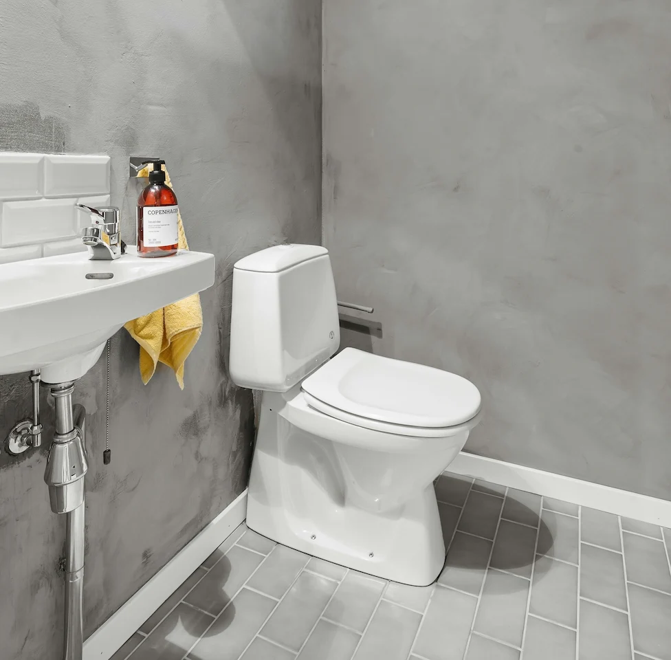 Salle de bain moderne avec lavabo et toilettes, espace propre et bien éclairé