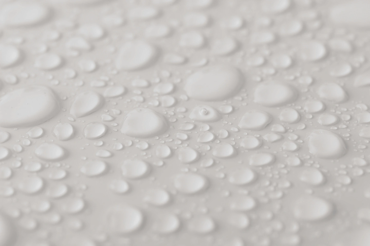 Gouttes d'eau cristallines sur une surface lisse, macro photographie avec un fond flou