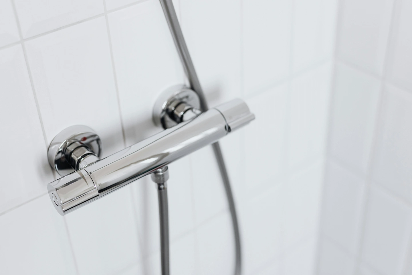 Gros plan d'un mitiguer thermostatique de douche en chrome avec jets d'eau, pomme de douche moderne, intérieur de douche