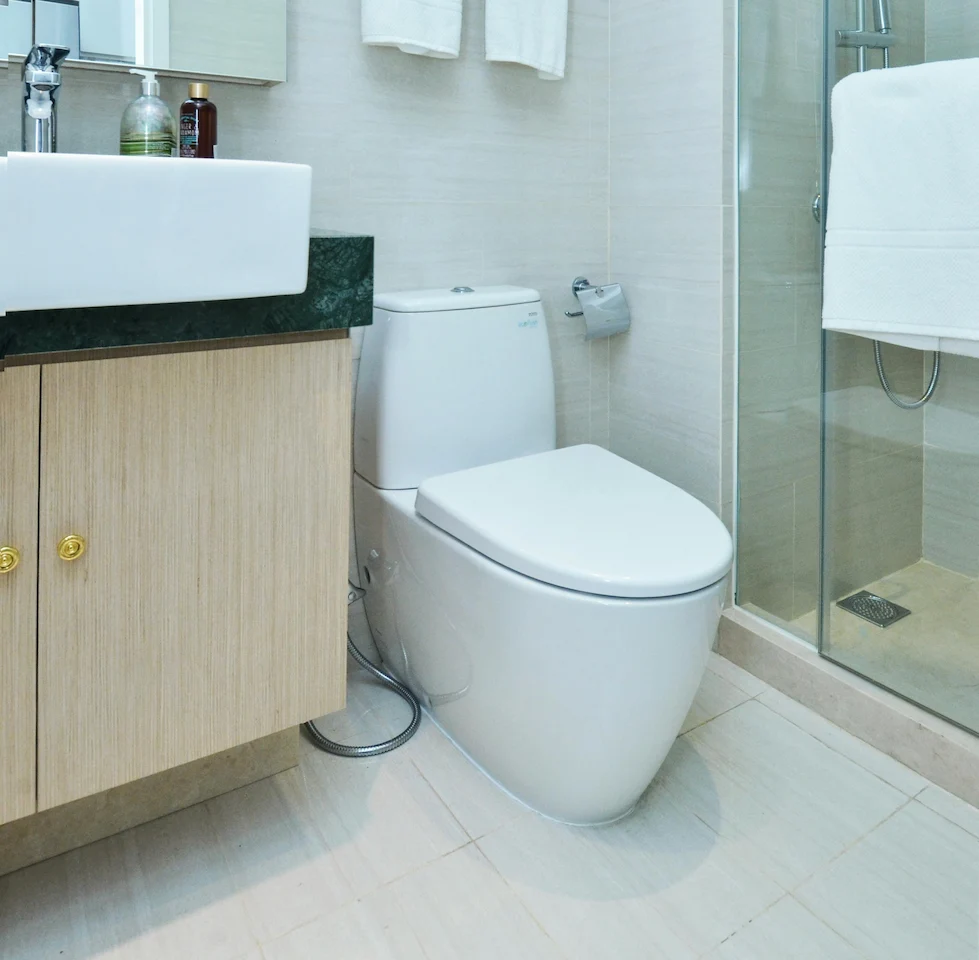 Salle de bain moderne avec toilettes, douche et lavabo, espace propre