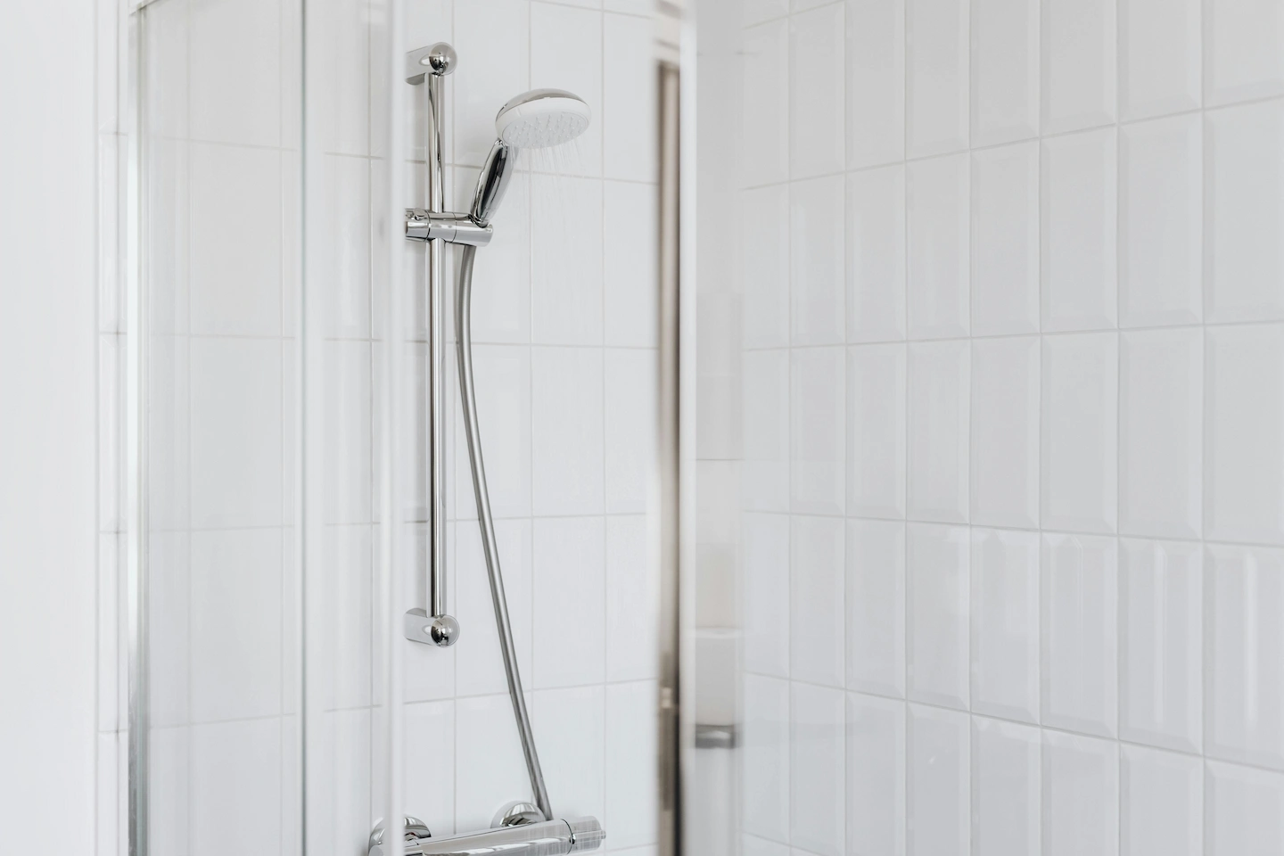 Pomme de douche dans une douche de salle de bain blanche et élégante, design contemporain