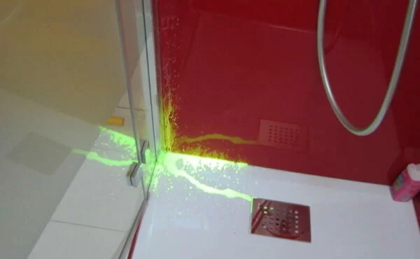 Homme tenant un bouton de chasse d'eau sur un réservoir de toilettes, réparation sanitaire