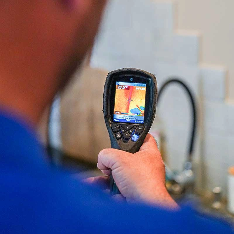 Homme en t-shirt bleu réparant des toilettes, dépannage professionnel plomberie