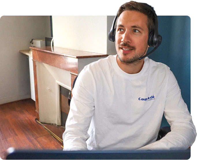 Homme portant un casque avec micro, assis et regardant sur le côté dans un bureau.