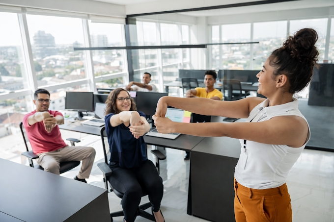 Séance d'étirements et de réveil musculaire au bureau : une coach anime un atelier de bien-être en entreprise pour prévenir les TMS et booster l'énergie des collaborateurs.
