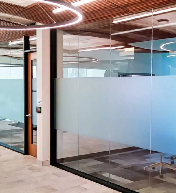 an office with glass walls and a wooden ceiling