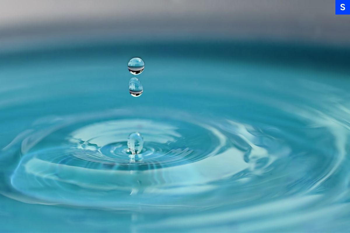 Some drops of water splashing into a pristine pool