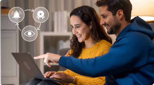 Smiling man and woman looking at a laptop screen with notification and reward icons above.