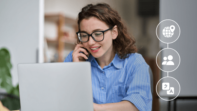 Smiling warehouse worker wearing an orange hard hat and holding a tablet, standing between shelves filled with boxes.