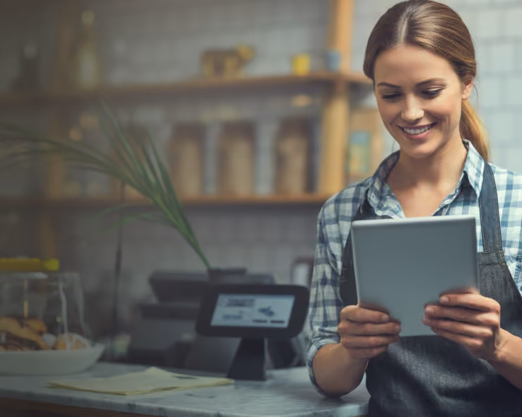 Retail associate serving a customer on a tablet running Kensium POS on the shop floor