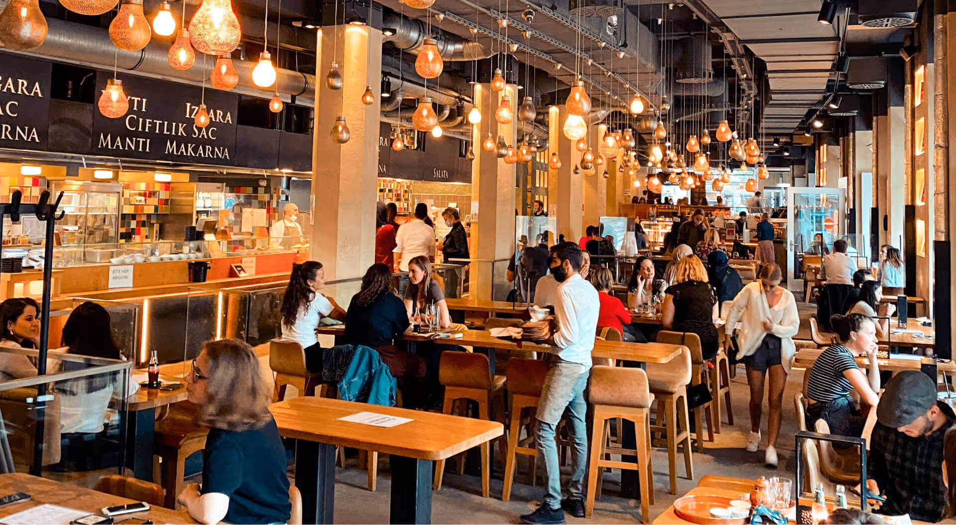 A group of people sitting at tables in a restaurant.