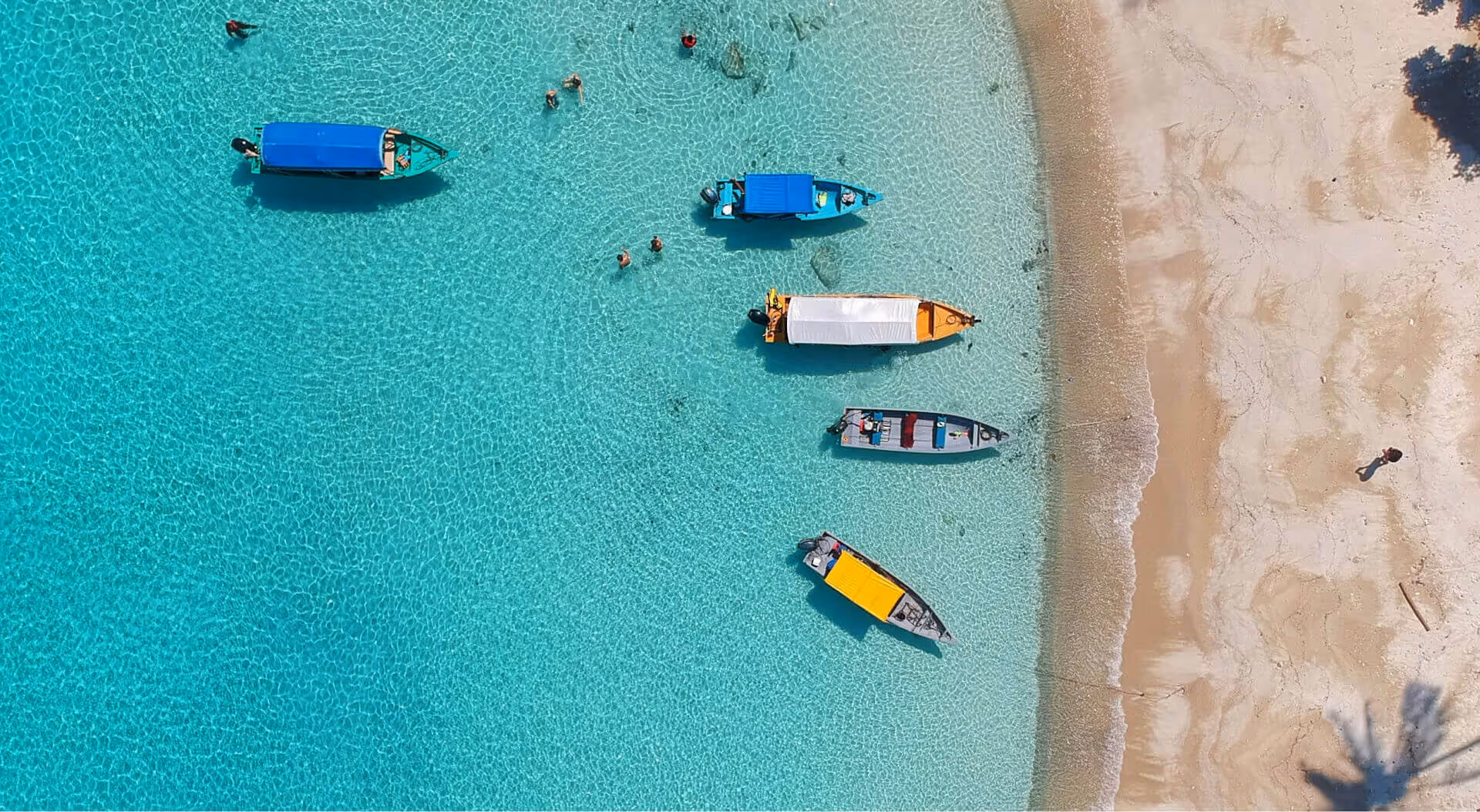 A group of boats floating on top of a blue ocean.