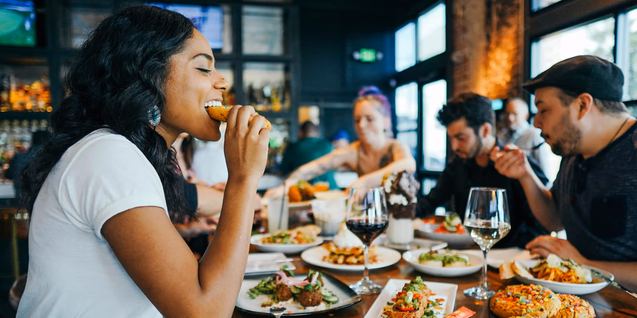 A group of people sitting around a table eating food.