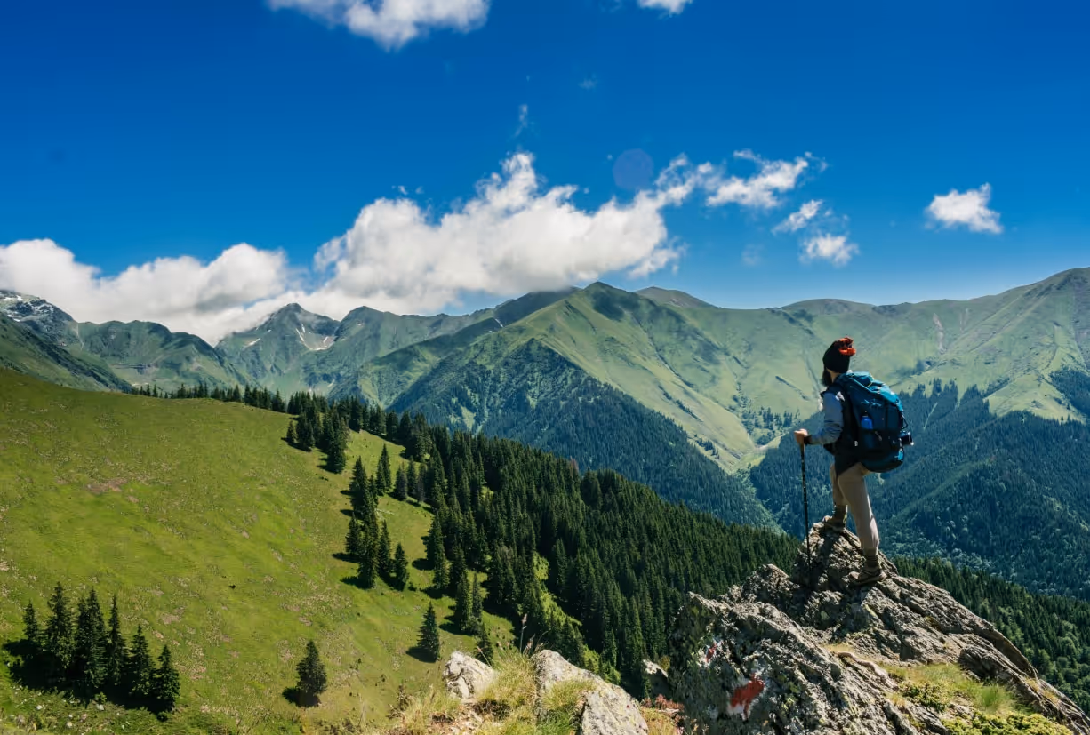 A man with a backpack standing on top of a mountain.