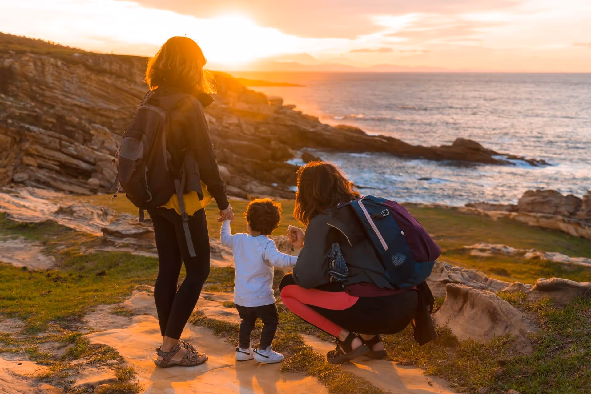family looking sunset coast by sea