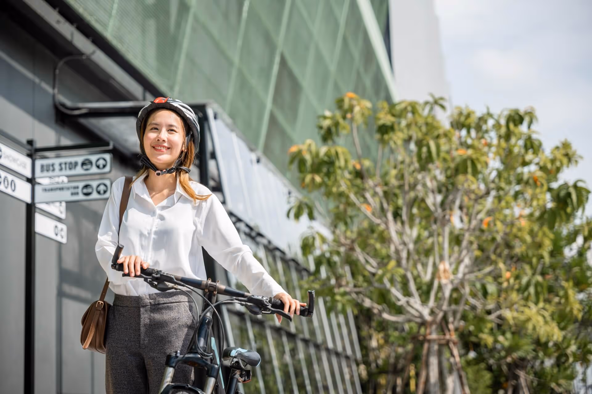 Lady walking with her bike net to building