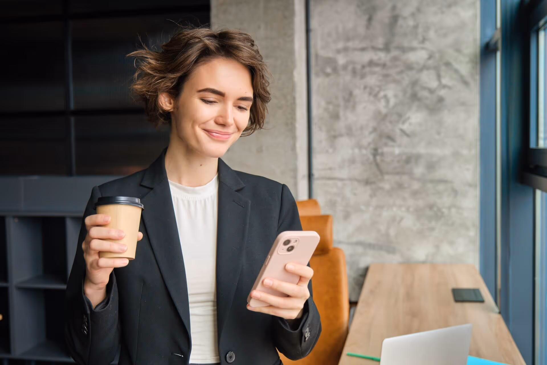 Women drinking coffee while looking at phone