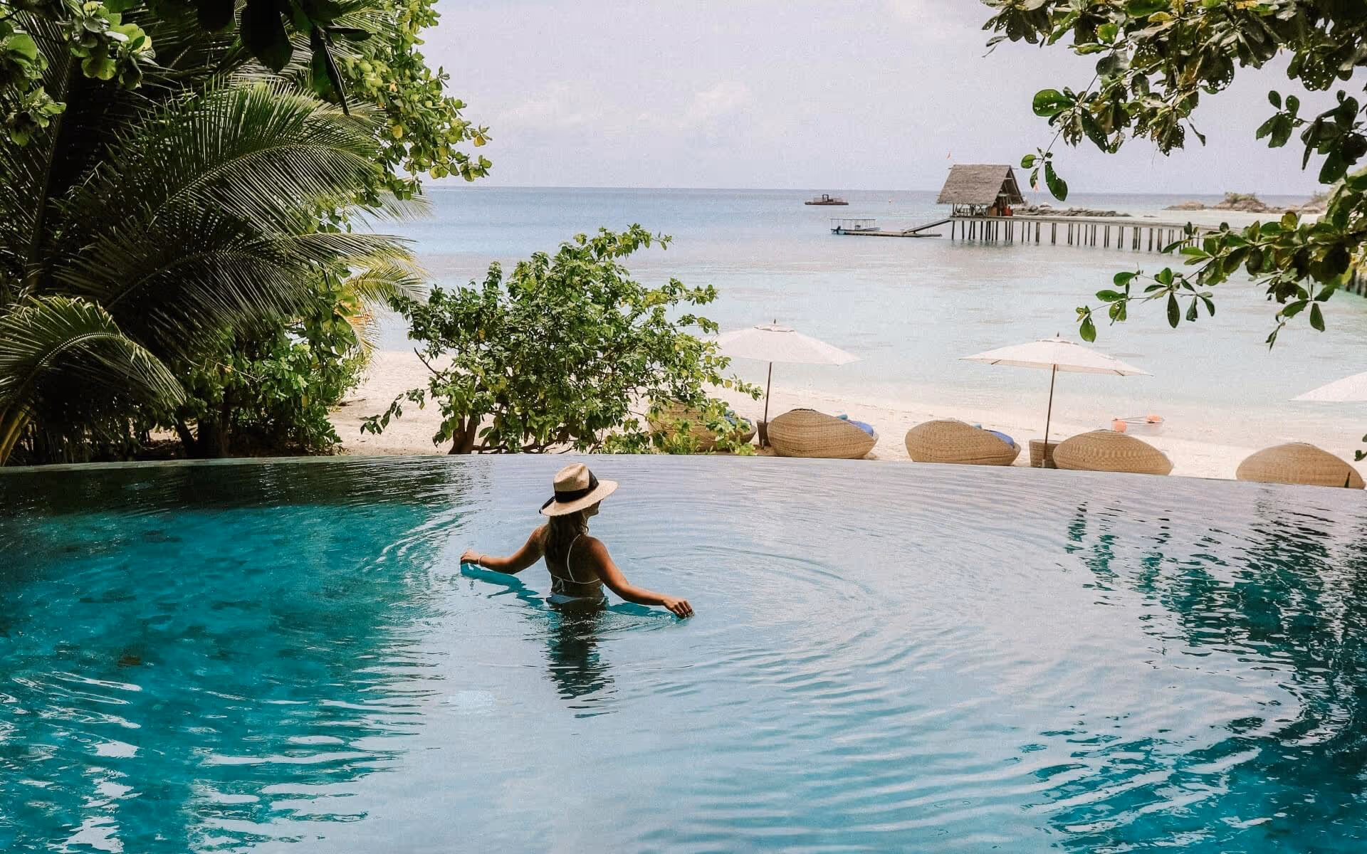 Women swimming in a pool looking at the beach