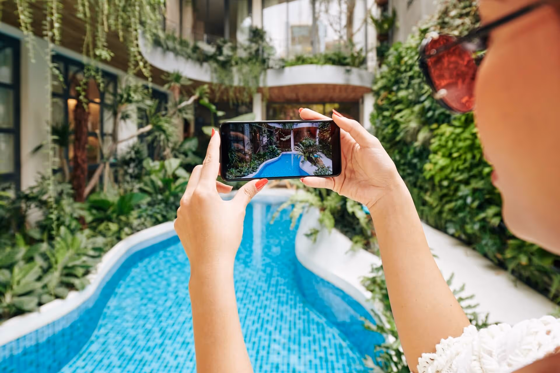 Person taking photo of swimming pool at hotel