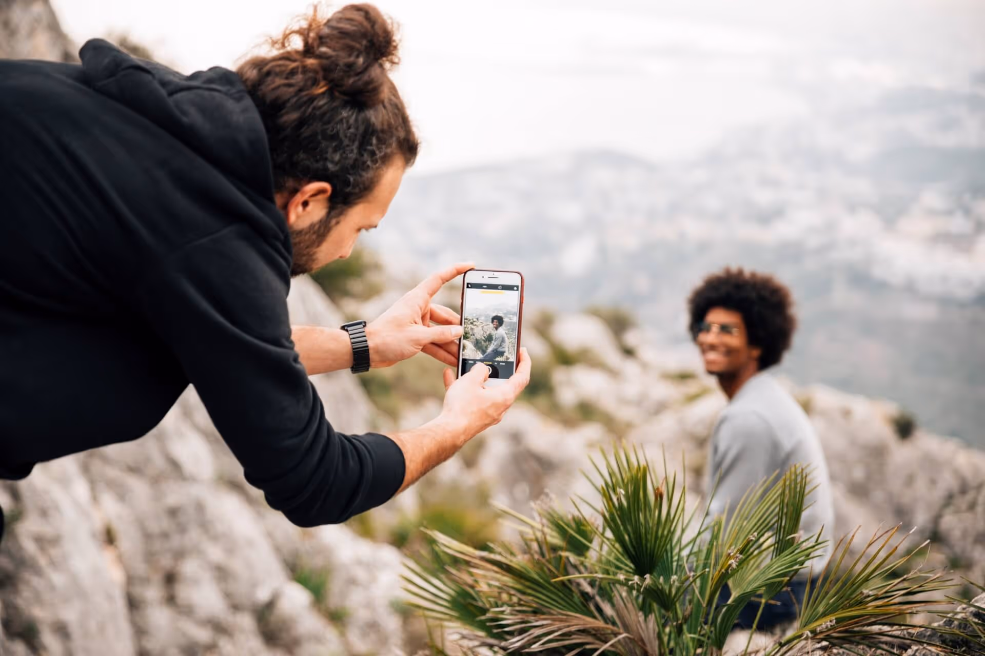 Guy taking photo of friend on cliff side