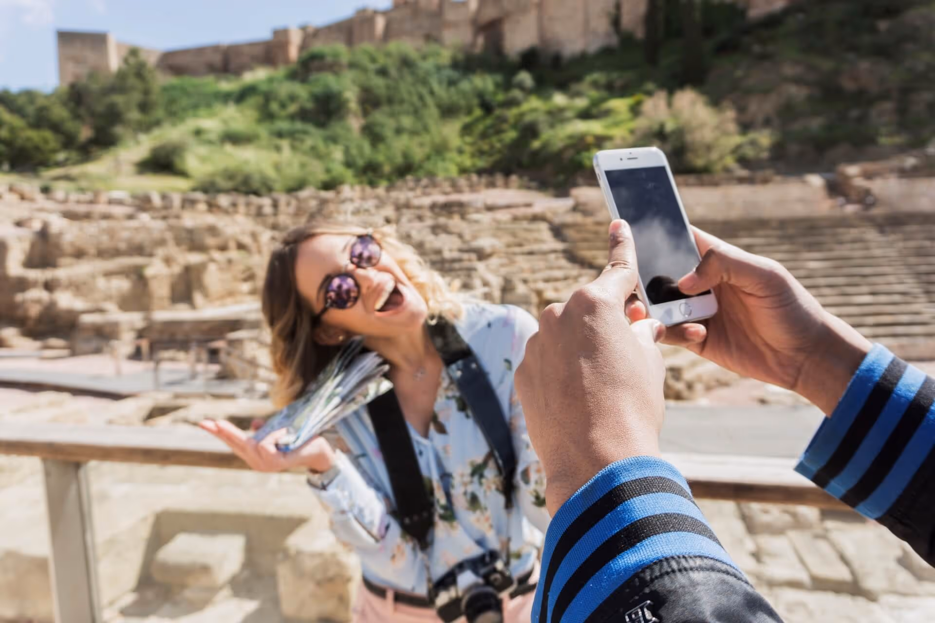Taking photo of smiling girlfriend in front of monument