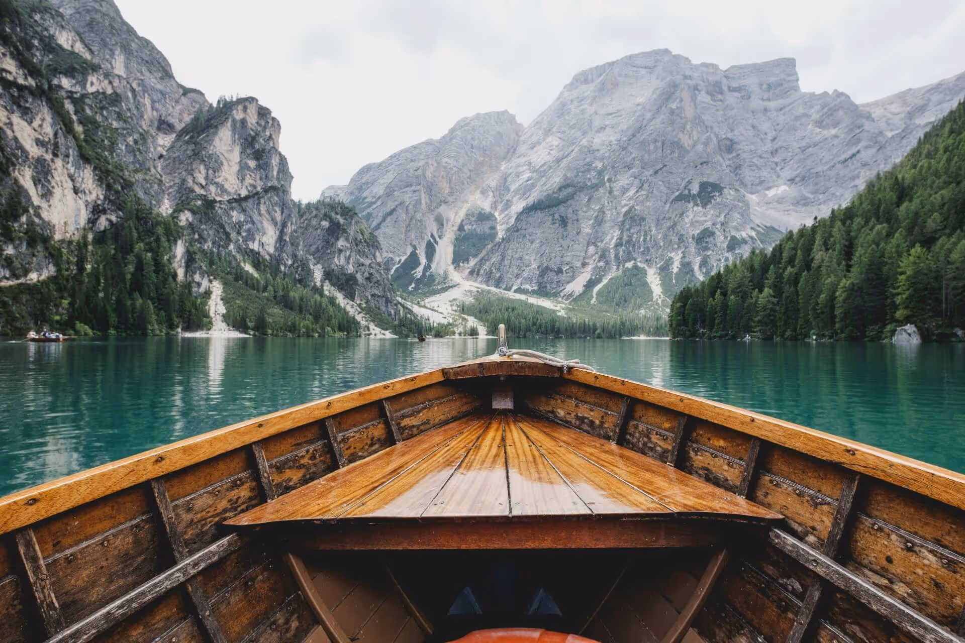 Wooden boat moving towards the mountains