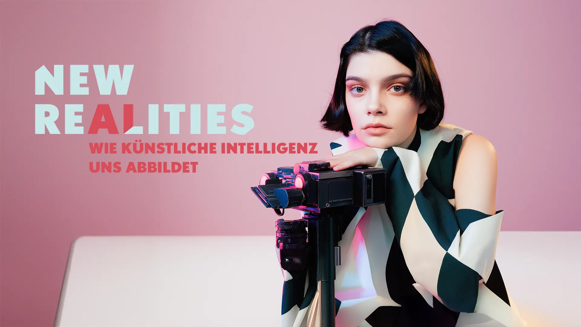 Junge Frau vor rosa Hintergrund, den Kopf und die Hand abgestützt auf einer Kamera auf einem Stativ; daneben der Schriftzug «New Realities: Wie Künstliche Intelligenz uns abbildet».