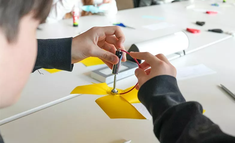 Junge konzentriert am Arbeiten mit einer Batterie.
