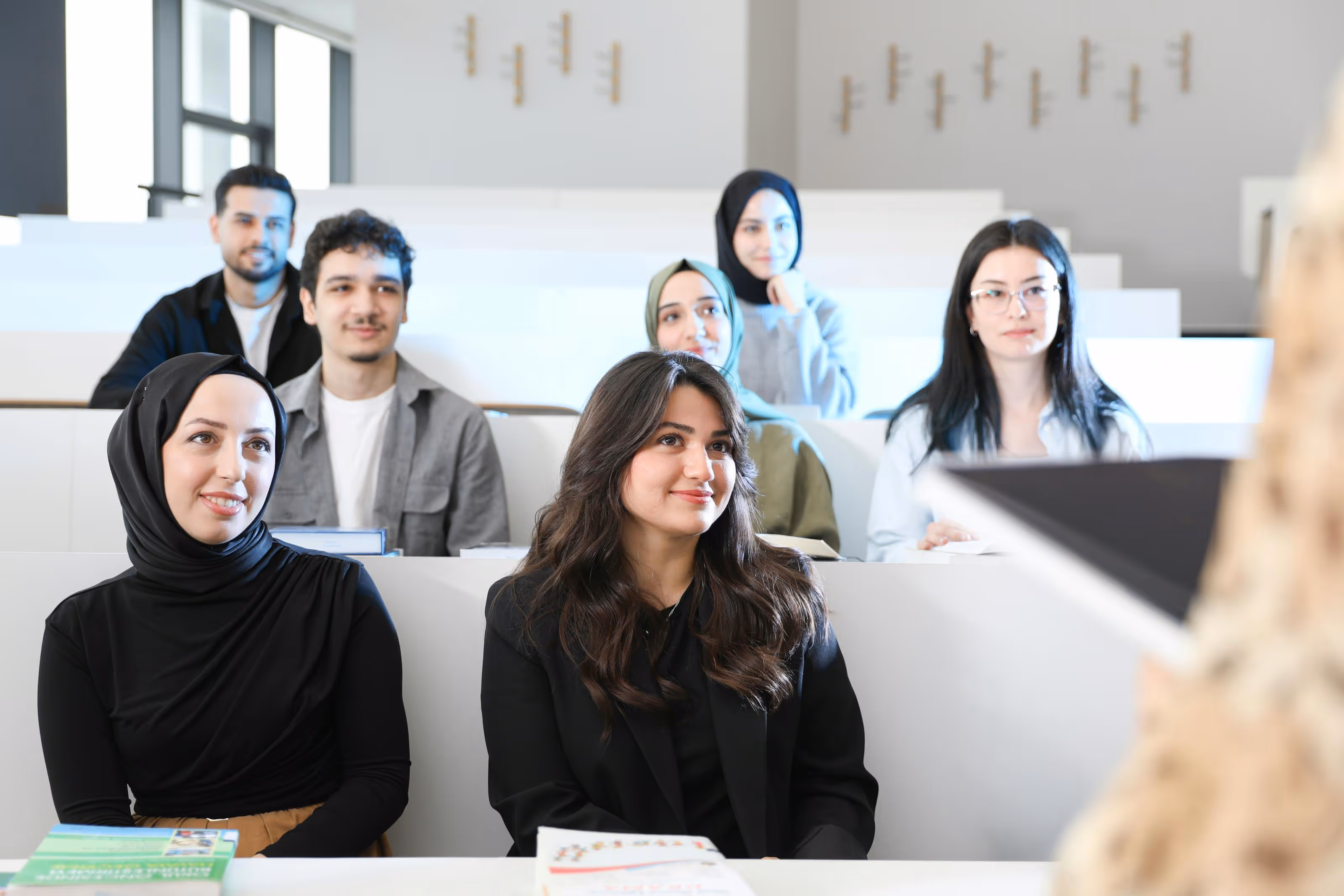 Mixed group of alert students in a busy lecture hall
