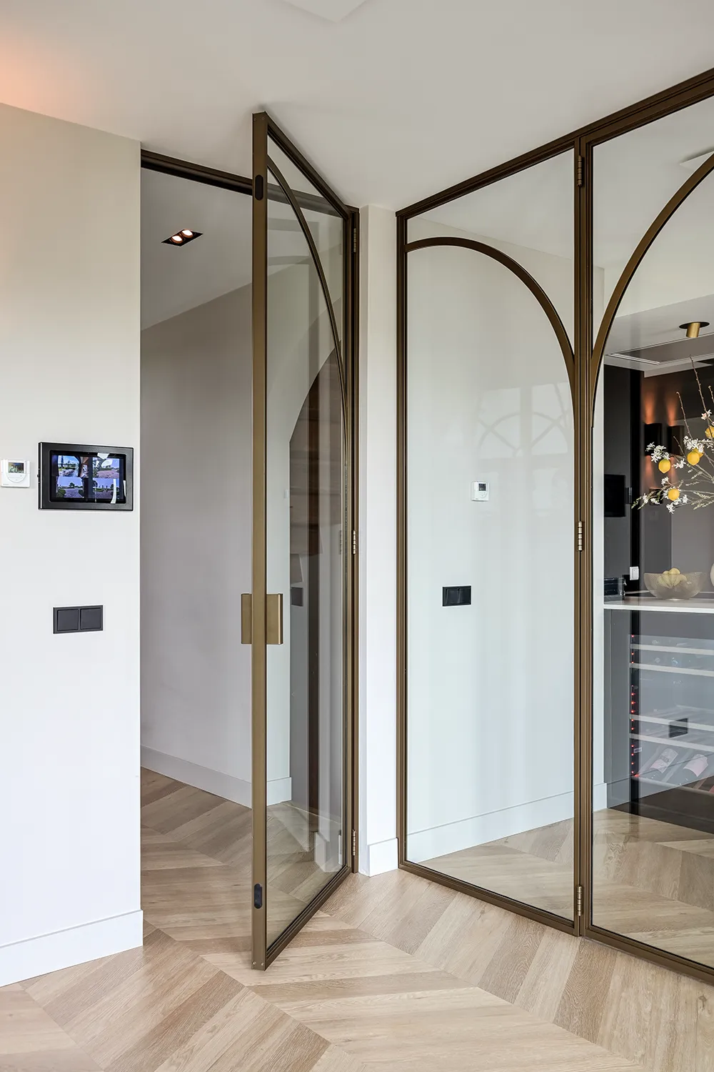 Moderne Aluminium-Lofttür in bronzener Farbe mit flachen gebogenen Sprossen im Rundbogen-Design. Fester kleiner Winkelgriff mit Magnetverschluss.