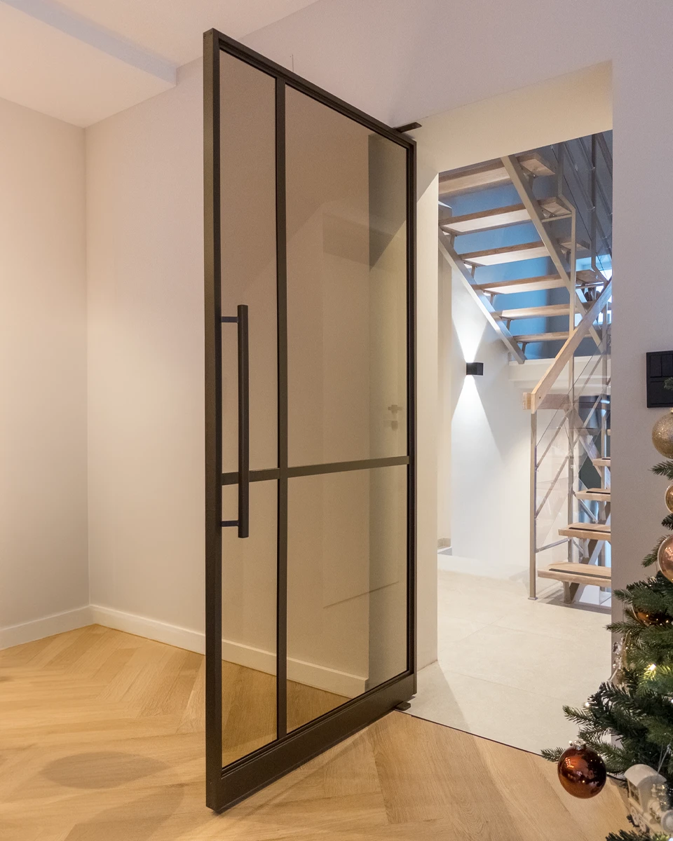 Foto einer geöffneten Pivottür mit einer vertikalen und einer horizontalen Sprosse. 