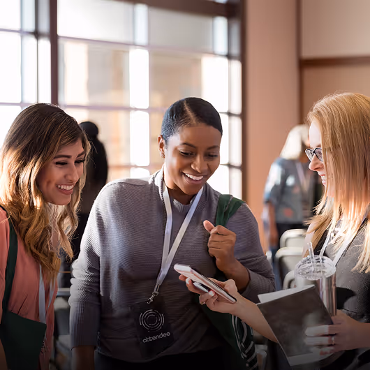 Trois femmes échangeant autour d’un stand lors d’un salon professionnel