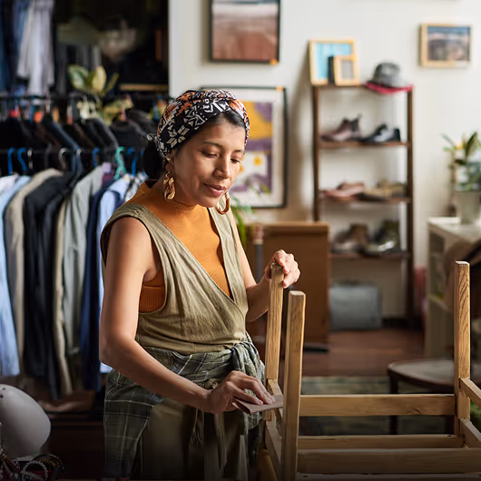 Femme arrangeant des vêtements dans une boutique de mode