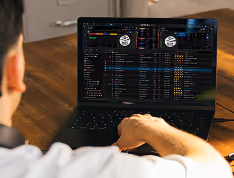 Person viewing a laptop screen displaying a dark-themed data or media management interface.