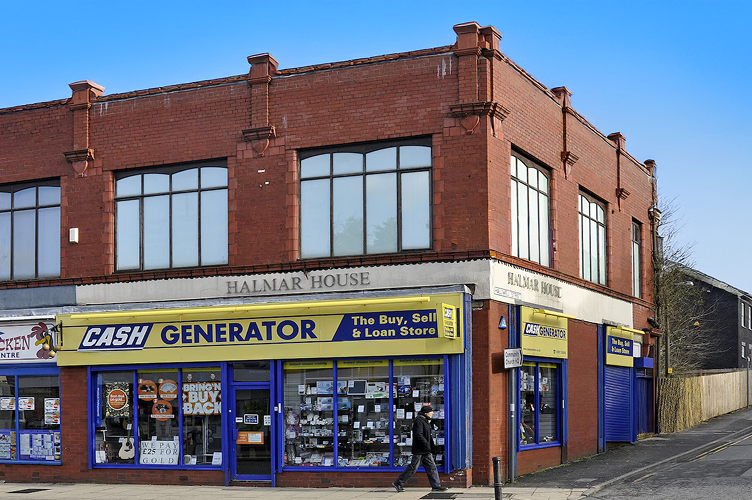 Red brick commercial building on a corner plot in Chorley town centre, featuring ground floor retail units, being converted into shops and a 7-bed HMO with heavy refurbishment finance from Lendhub
