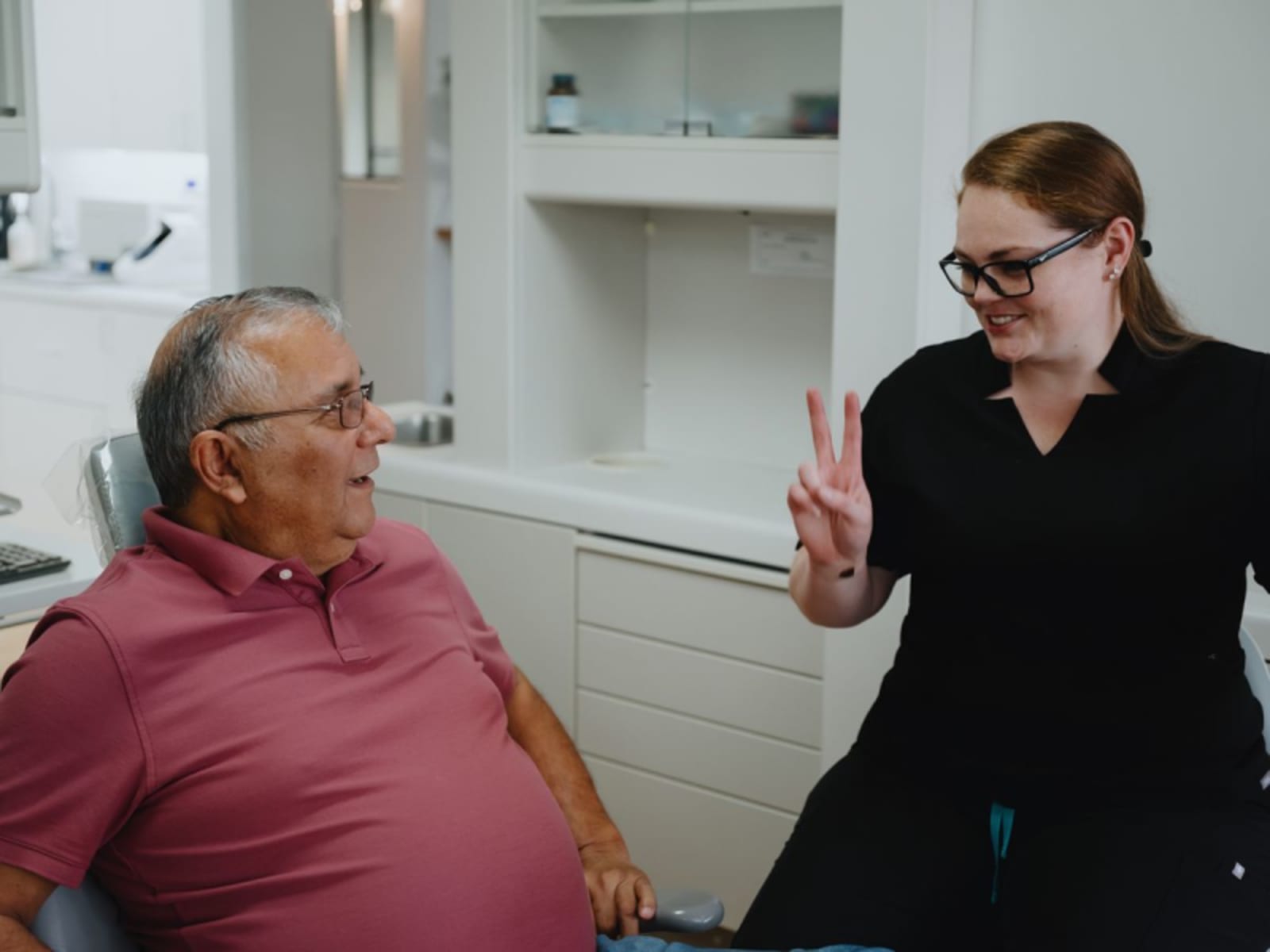 Female dentist consulting with male patient in clinical setting