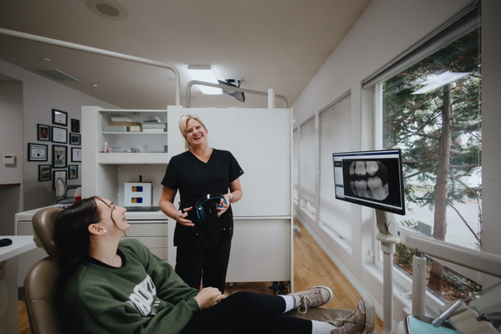 Pediatric dental exam room with dentist and young patient sitting in treatment chair