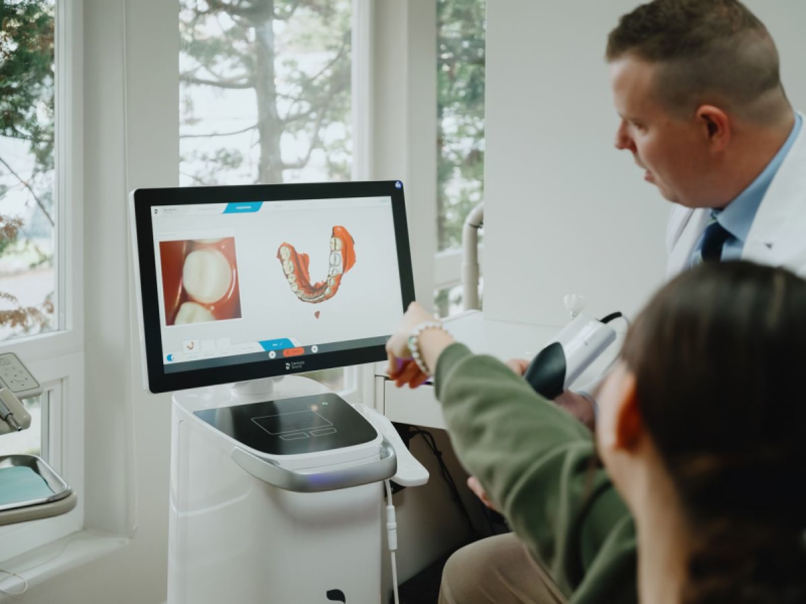 Dentist and patient reviewing digital crown design on computer screen together