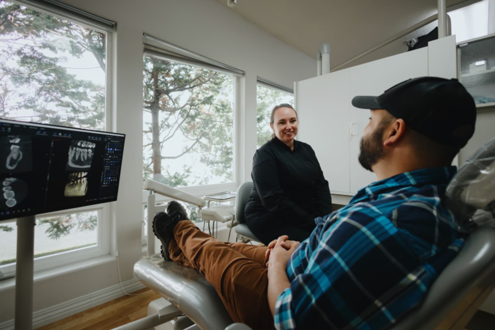 Dentist showing patient X-rays and explaining treatment plan in comfortable office setting