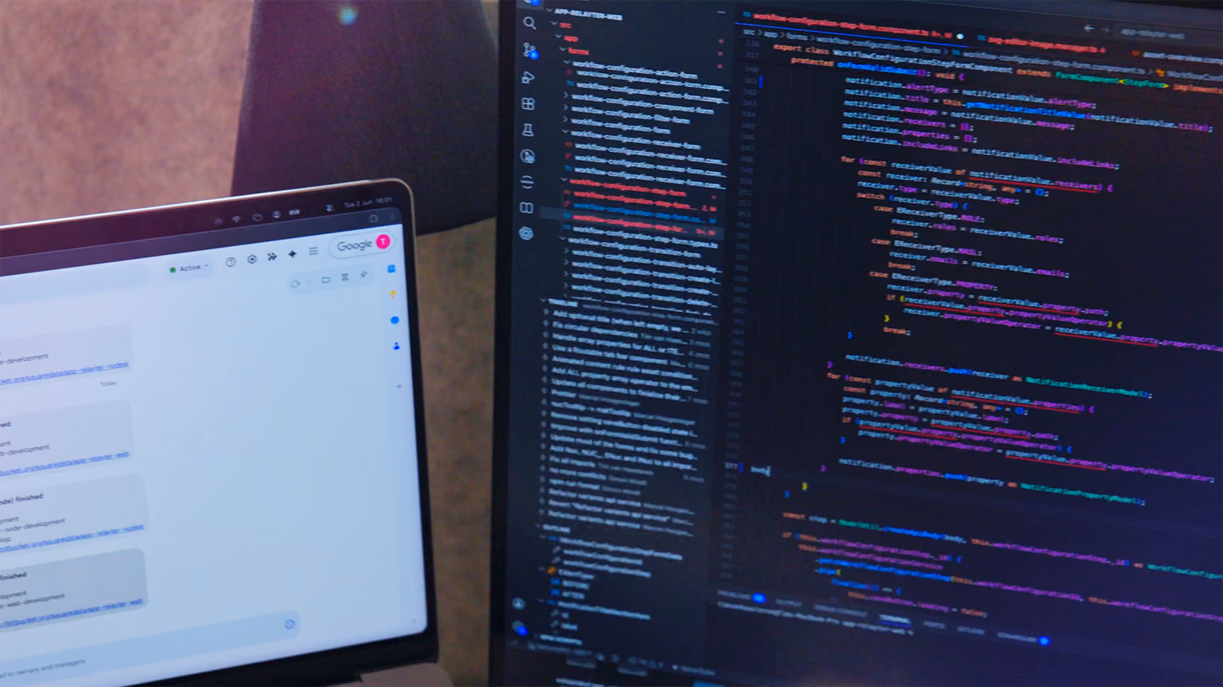 Laptop- en monitorscherm met programmeercode in een ontwikkelomgeving