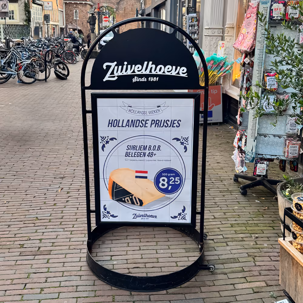 Stoepbord van Zuivelhoeve met een kaasaanbieding op een winkelstraat