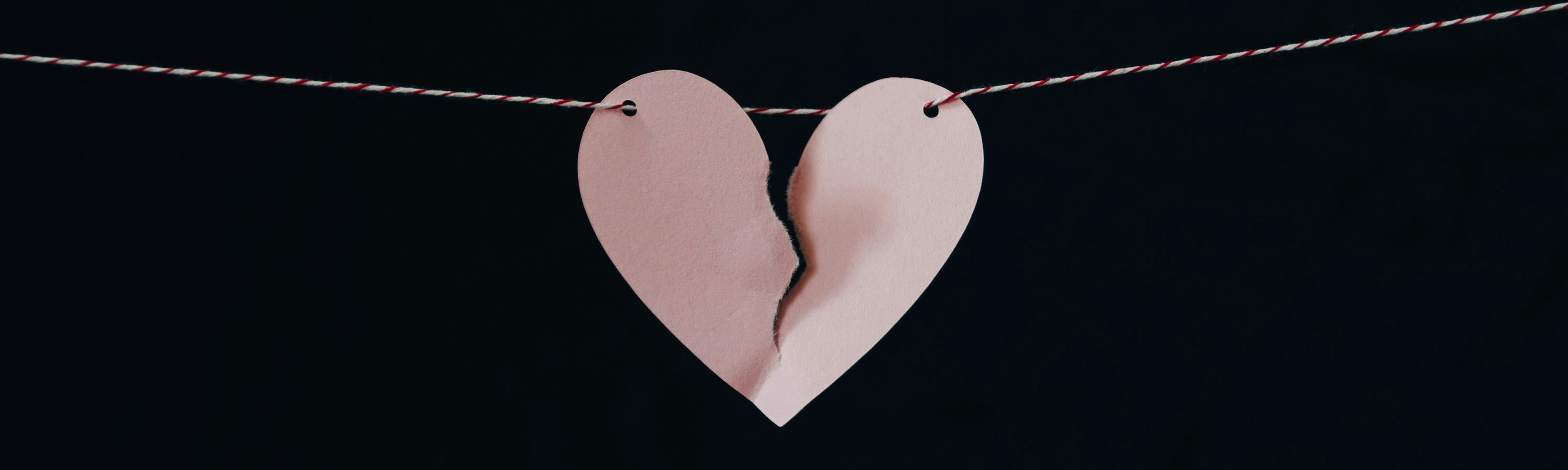 Pink paper heart ripped in half.