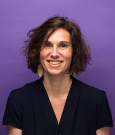 Anne-Gaëlle Le roux, directrice clientèle à l'agence, de face sur un fond mauve, souriante