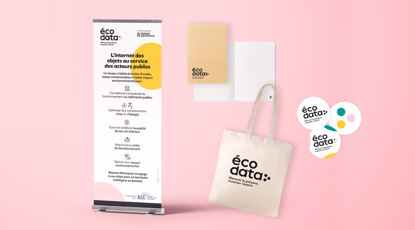Ensemble de supports imprimés pour la marque écodata : kakemono, carnet, tote bag et stickers, sur fond rose pastel.