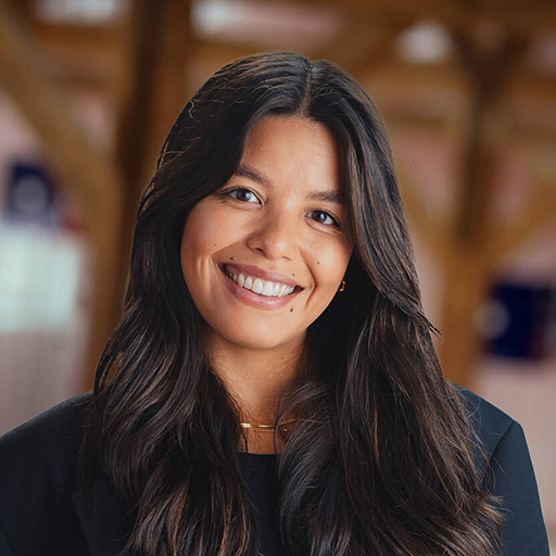 A woman with long dark hair smiling at the camera.