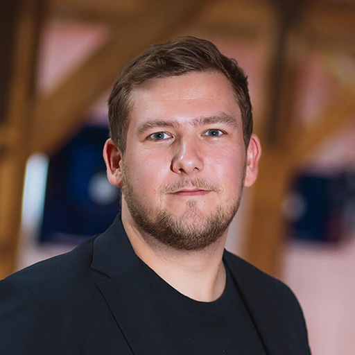 A man with a beard and a black shirt.